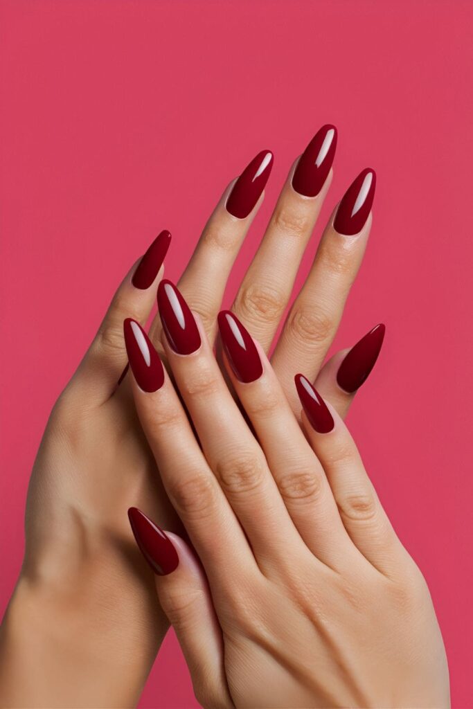 A hand displaying rich, red deep ruby acrylic nails, luxurious and elegant, perfect for evening events and adding sophistication