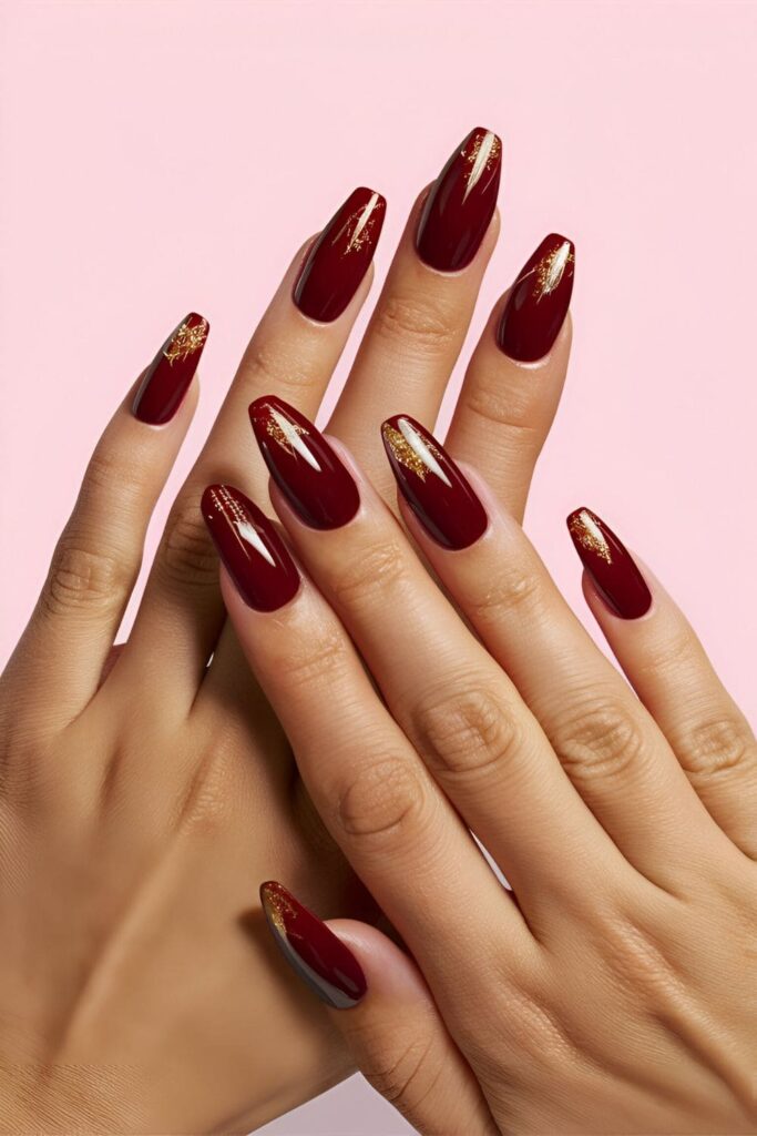 A hand featuring deep, dark vampy red acrylic nails, passionate and sophisticated, ideal for evening events and special occasions