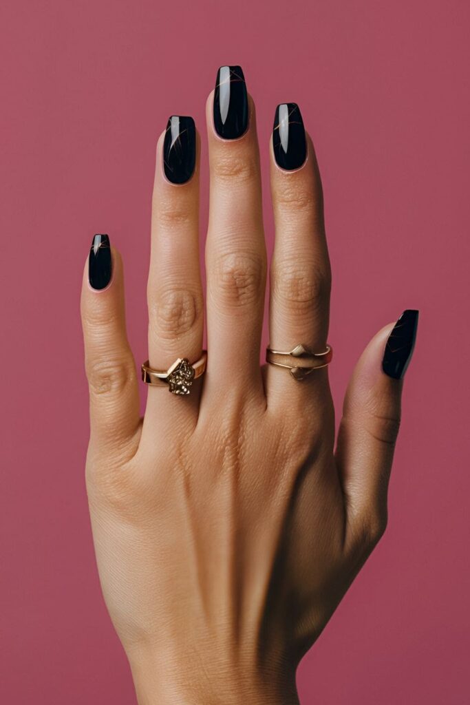 A hand featuring onyx acrylic nails with subtle shimmer, striking and dramatic, perfect for evening events or nights out