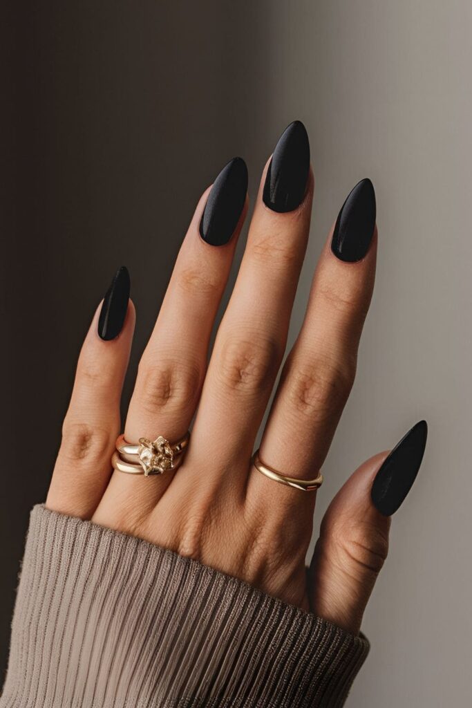 A hand showcasing velvet black acrylic nails with a deep, rich black color and hint of softness, timeless and elegant for any occasion