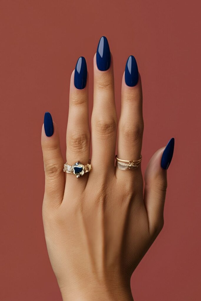 A hand with luxurious sapphire blue acrylic nails, sophisticated and versatile, suitable for both casual and formal occasions