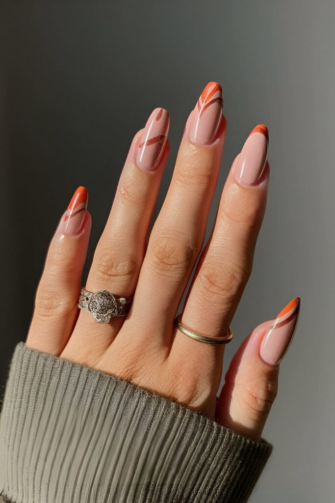 Acrylic nails combining orange with soft mauve accents or patterns, understated and elegant nail design