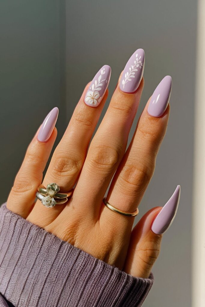 Acrylic nails in a soft lavender shade, featuring delicate white floral designs for a feminine and understated look