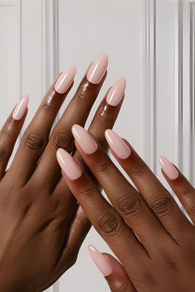 Acrylic nails in soft baby pink with a glossy and matte finish, designed to complement dark skin tones