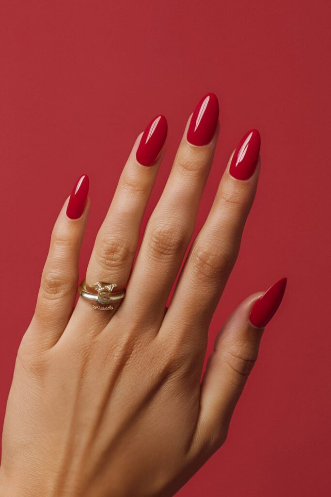 Acrylic nails painted in a bold, vibrant red shade, exuding confidence and style for any occasion