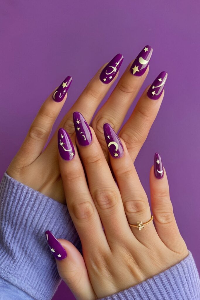 Acrylic nails with a purple base, decorated with celestial designs including moons and stars, either as decals or hand-painted, for a dreamy look