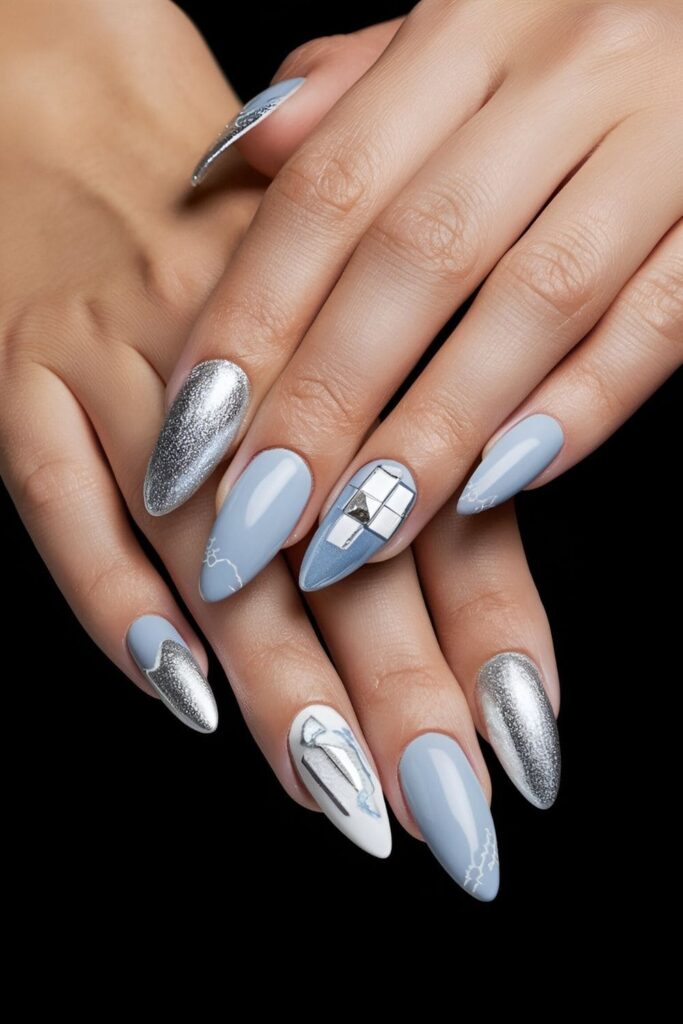 Almond nails with a light blue base, silver glitter, and foil accents