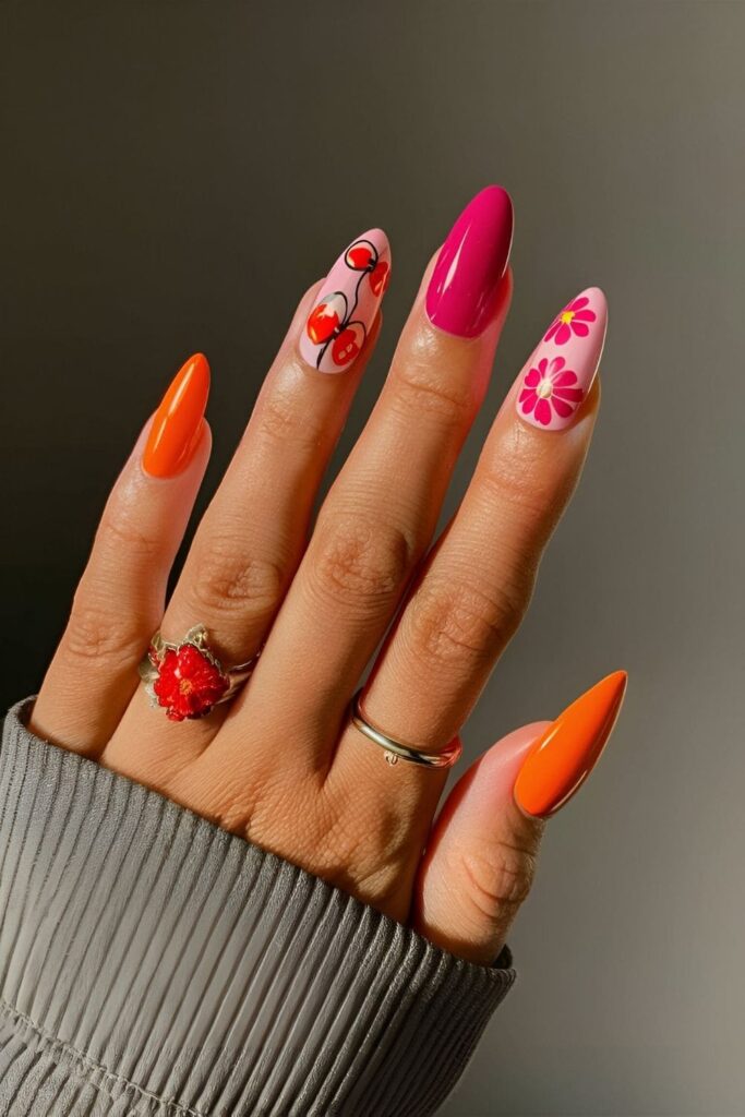 Almond nails with big, bold floral designs in vibrant colors like red, pink, and orange on a contrasting base color