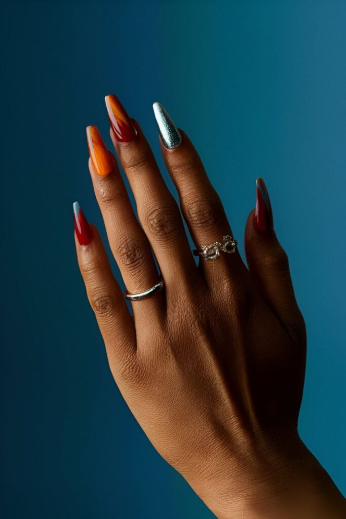 Aura nails with a striking contrast of fiery reds, oranges, cool blues, and silvers for a bold look