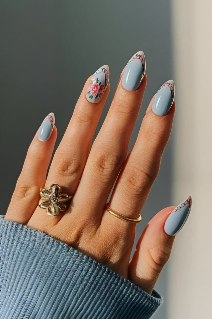 Baby blue nails with detailed floral designs on the tips, providing a soft and feminine appearance.