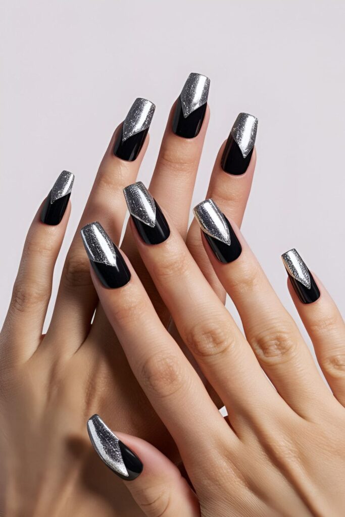 Black acrylic nails accented with shiny silver foil, giving a luxurious and futuristic touch