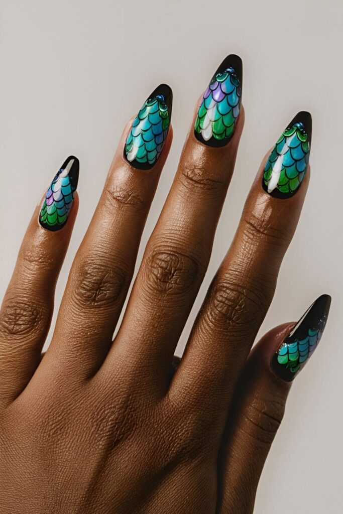 Black acrylic nails featuring whimsical mermaid scale designs in shades of blue, green, and purple