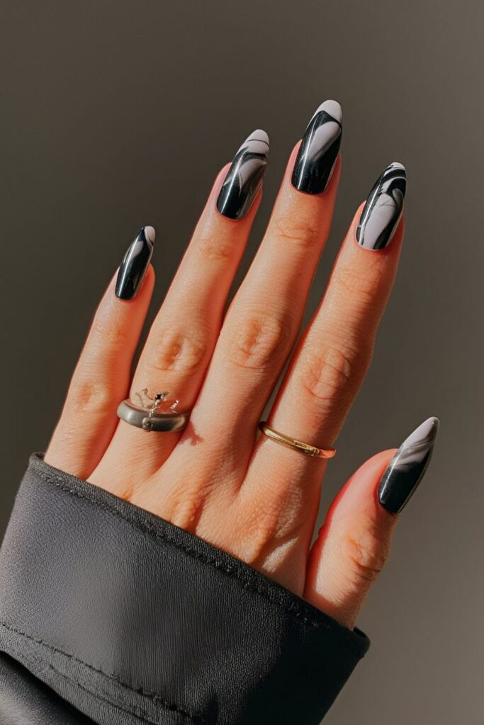 Black acrylic nails with a sophisticated marble effect in white and grey, adding depth and elegance