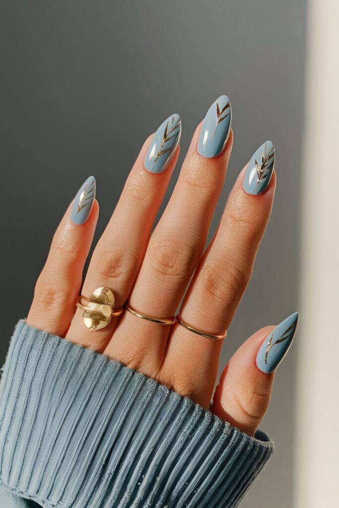 Blue acrylic nails with delicate feather patterns in gold or silver