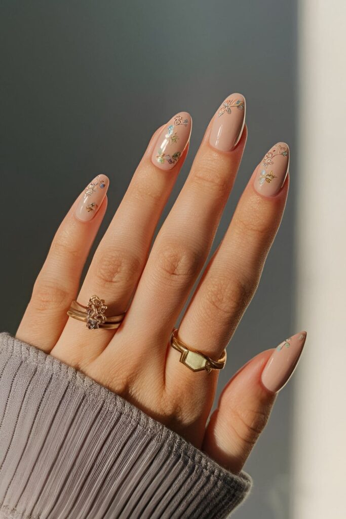 Blush nude nails with tiny, intricate soft-colored floral designs for a timeless and elegant look