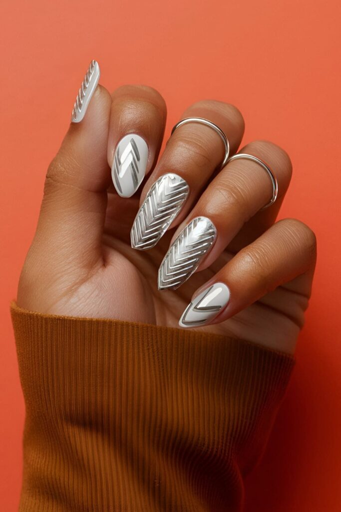 Bold nails with silver zigzag patterns created using a thin brush or tape on a contrasting base