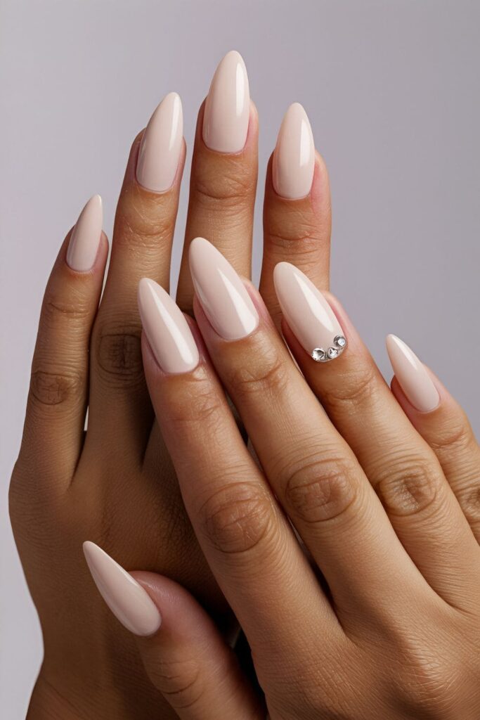 Bold stiletto-shaped nails with a simple, elegant design like nude polish or a single rhinestone accent