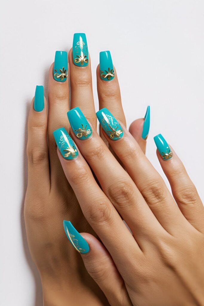 Bright turquoise acrylic nails with gold accents, creating a bold and beautiful look