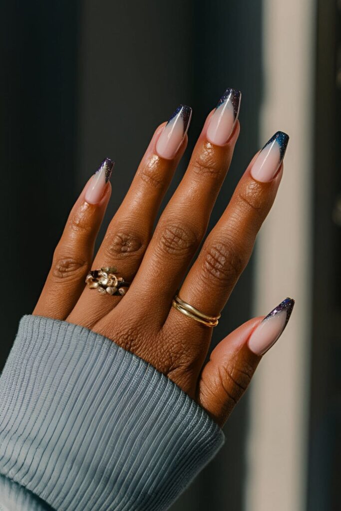 Dark-skinned hands with gradient tips and glitter-accented French manicure acrylic nails