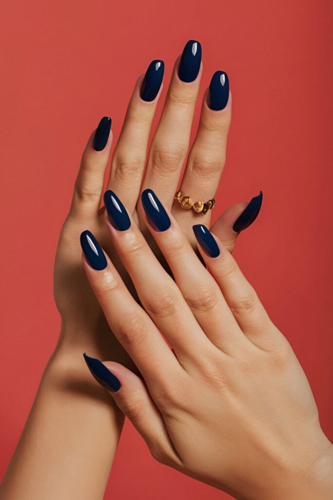 Close-up of hands with navy blue acrylic nails, featuring a glossy and elegant finish