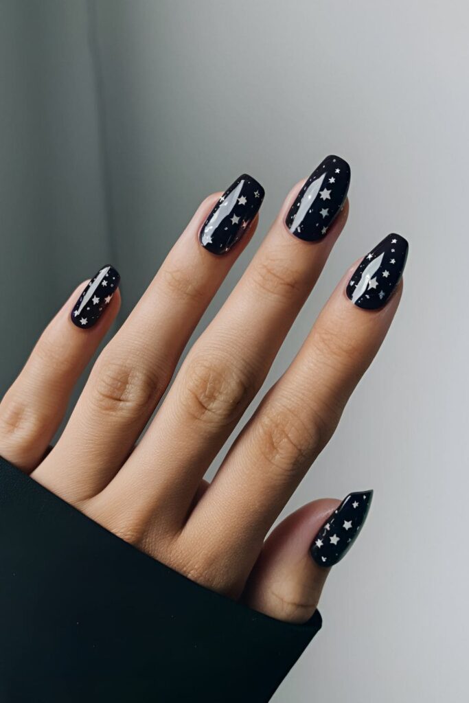 Dark base acrylic nails with tiny white and silver star designs for a dreamy, magical appearance