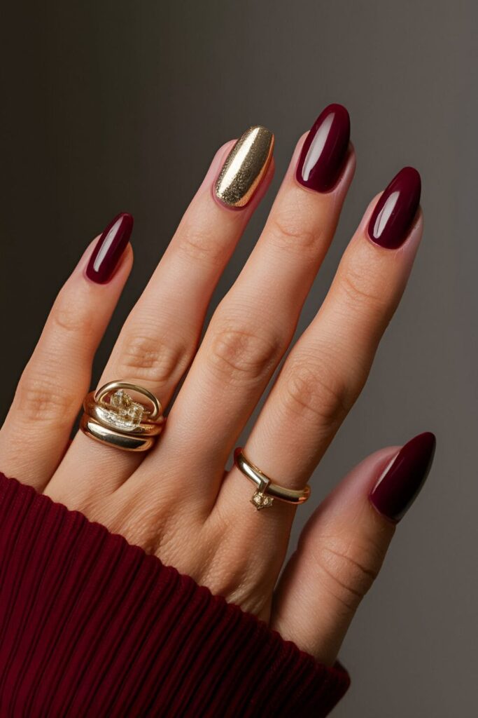 Deep maroon base nails with gold accents, creating a luxurious and stylish look perfect for fall