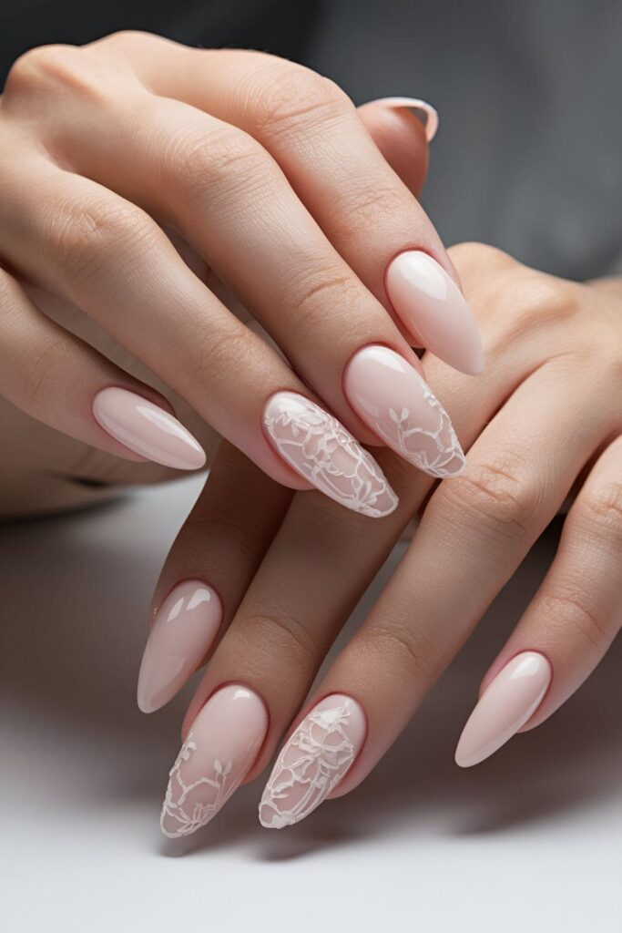 Delicate soft pink acrylic nails adorned with intricate lace patterns