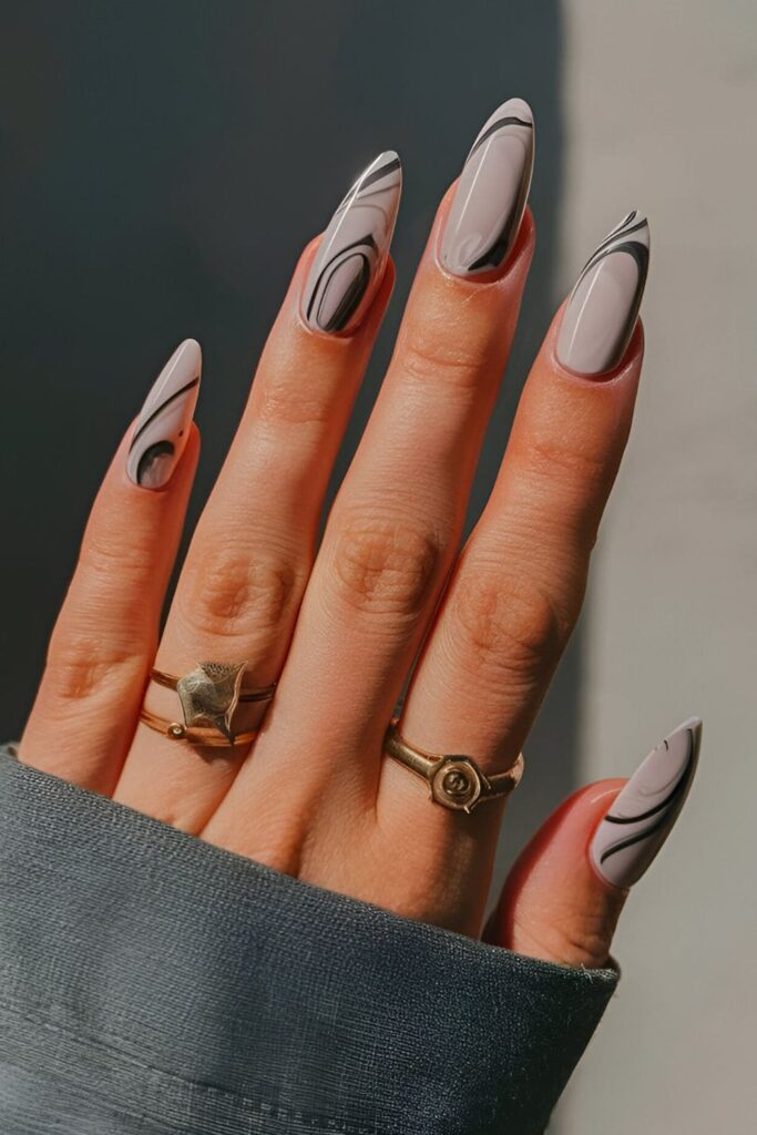 Elegant acrylic nails with a neutral base and swirls of white and grey, creating a sophisticated marble effect