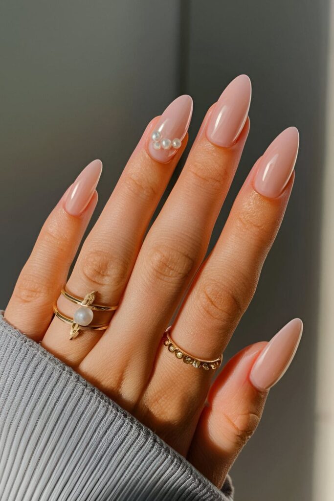 Elegant acrylic nails with tiny pearl embellishments on a soft base color, adding sophistication and refinement