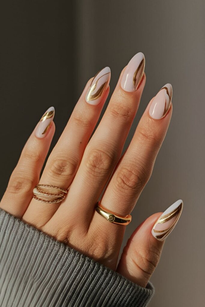 Elegant gold marble acrylic nails with white and gold swirls, perfect for a high-end, chic look