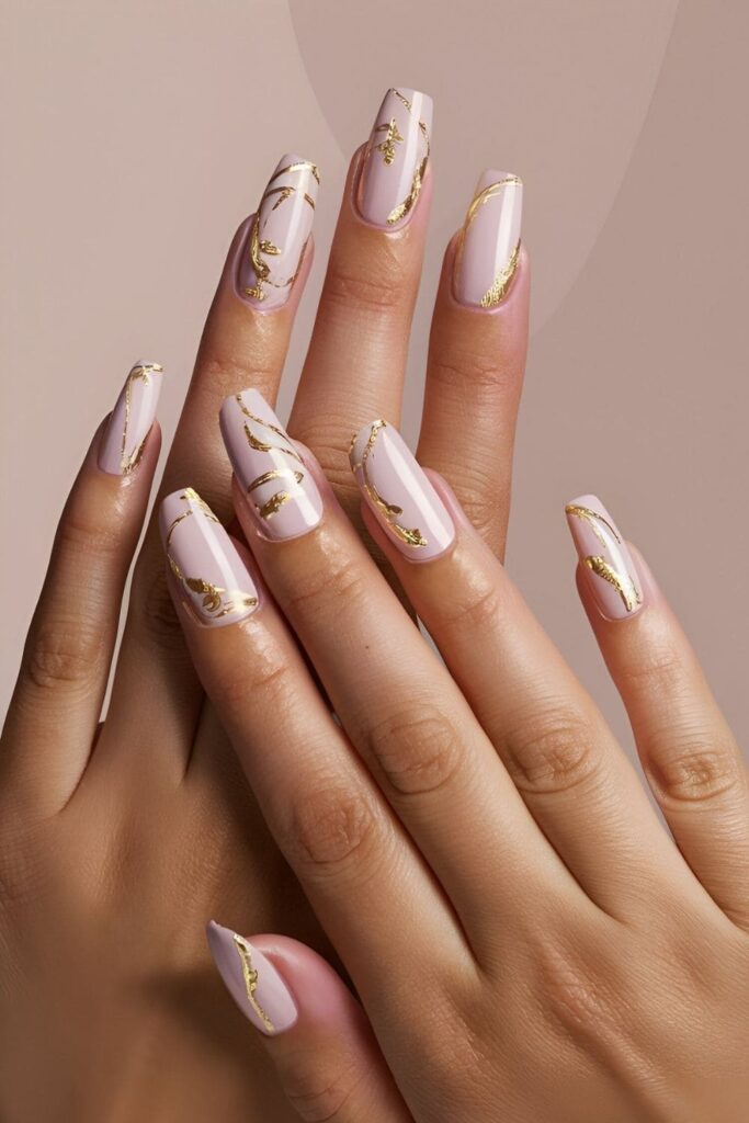 Elegant nude nails with gold foil accents in intricate patterns