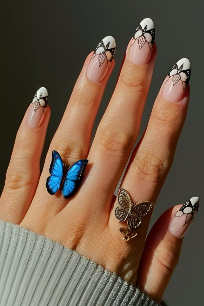 Enchanting-nails-with-intricate-blue-butterfly-wing-designs-on-a-light-base-with-black-and-white-accents