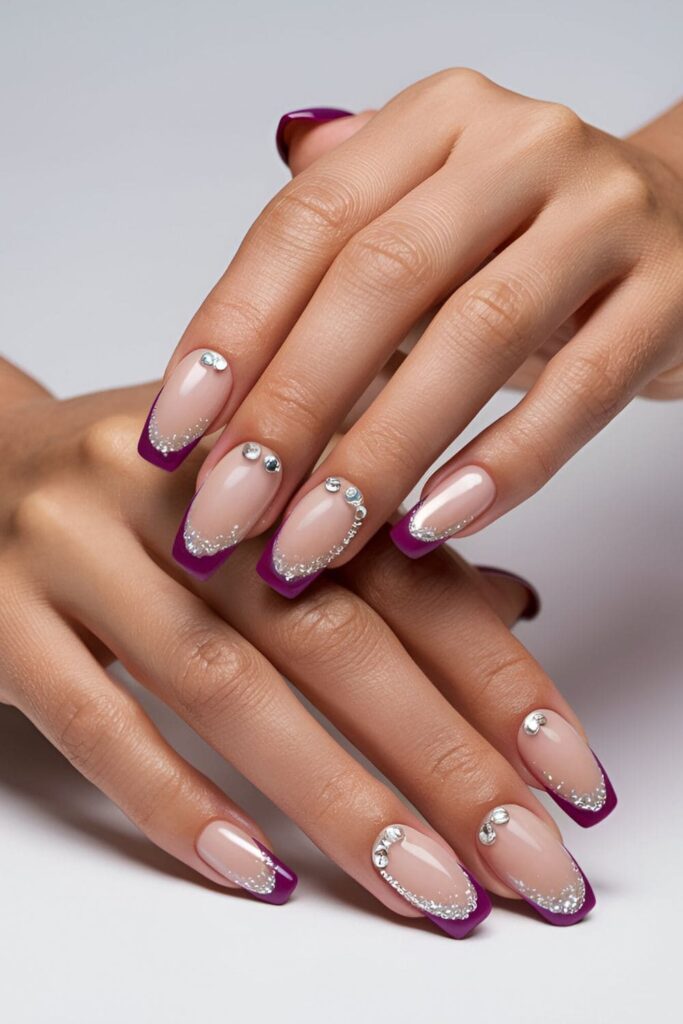 French manicure with nude bases and vibrant purple tips, accented with glitter or rhinestones for extra sparkle