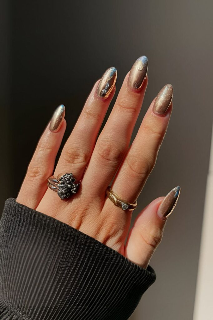 Glamorous gold acrylic nails with silver, bronze, and copper foil accents for a luxurious touch