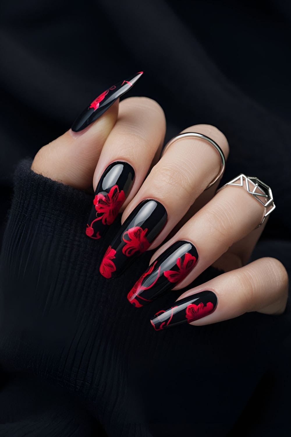 Gothic nail design with dark florals, featuring a black base and deep red, purple, or black flowers with detailed petals and leaves