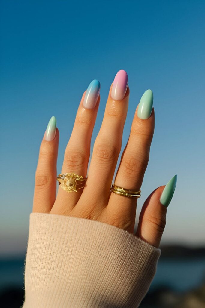 Gradient nails in pastel blues, pinks, and greens with a hint of shimmer, capturing the ethereal beauty of the aurora borealis