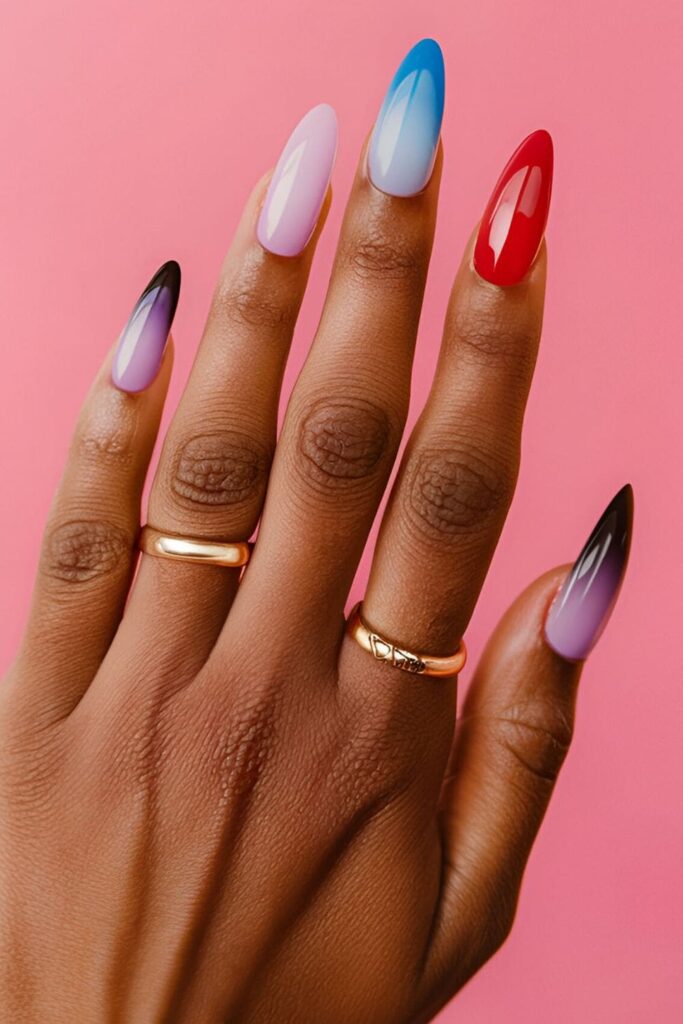 Gradient ombre acrylic nails transitioning from soft pink to vibrant red, pale blue to deep navy, and lavender to dark purple