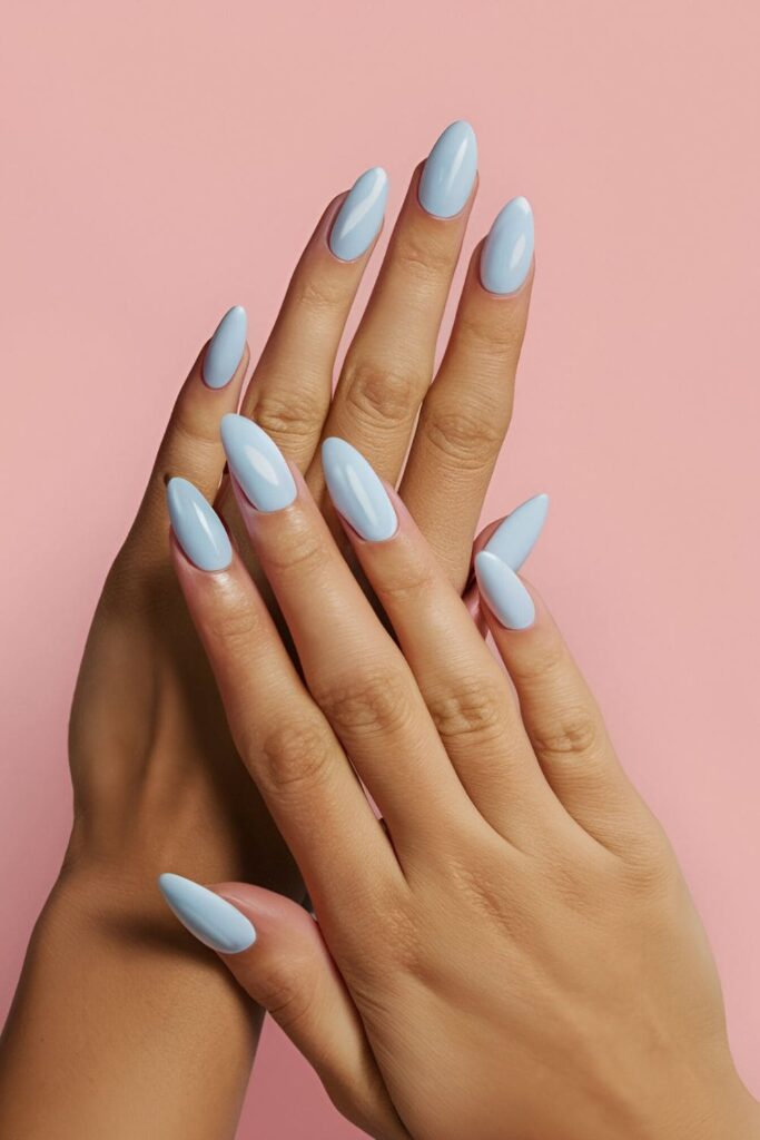 Hands showcasing baby blue acrylic nails with delicate white floral accents