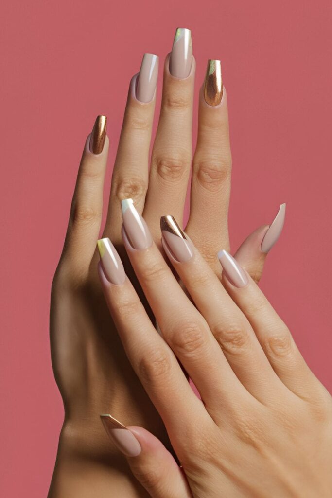 Image of hands with acrylic nails featuring a neutral base with touches of gold or silver metallic accents for a hint of luxury without being too flashy