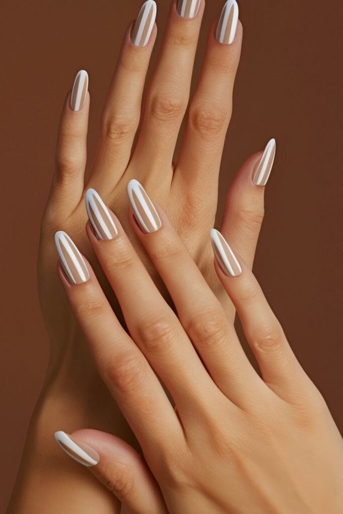 Image of hands with acrylic nails featuring thin stripes in white, beige, or gray on a neutral base, providing a simple yet stylish look