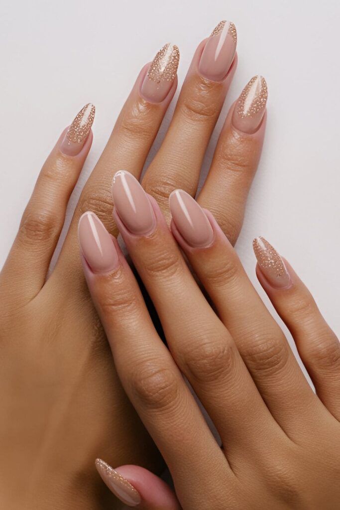 Image of hands with acrylic nails having a nude or pale pink base and a hint of glitter at the tips, adding a touch of sparkle without being overpowering