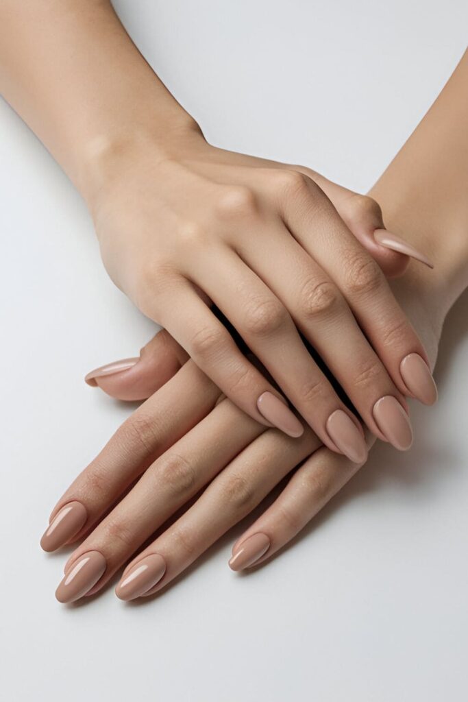 Image of hands with acrylic nails in a nude shade that matches various skin tones, highlighting a subtle and sophisticated look