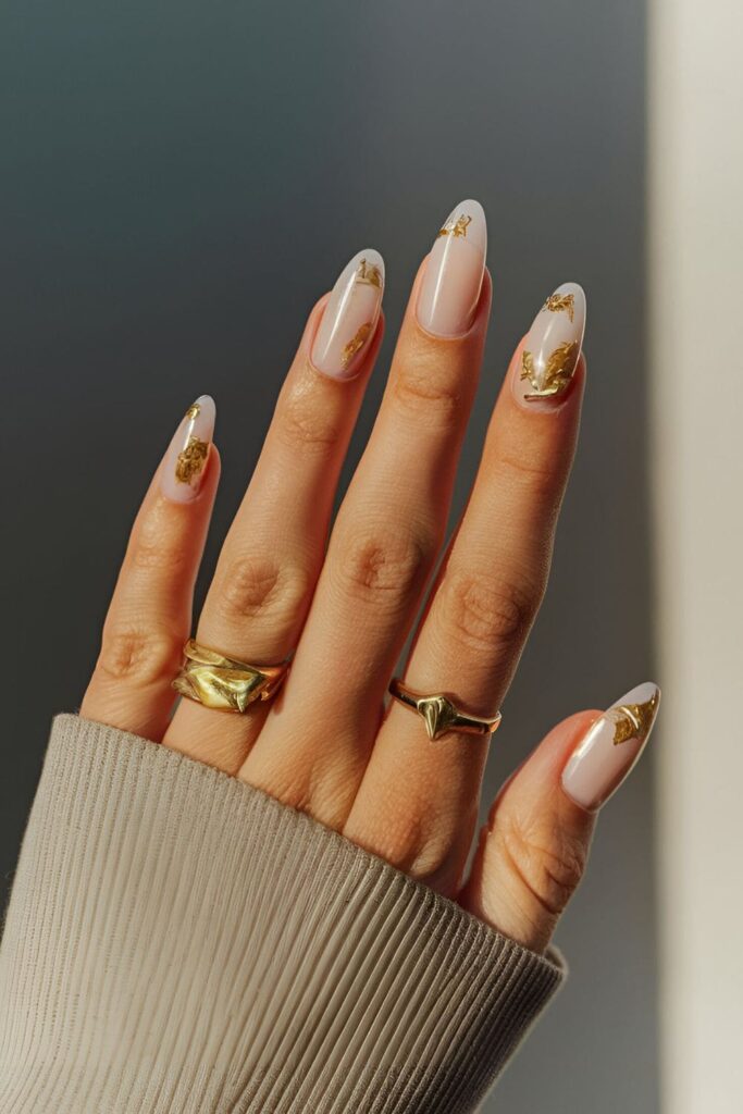 Light base acrylic nails with luxurious gold leaf accents, creating a high-end and stylish appearance