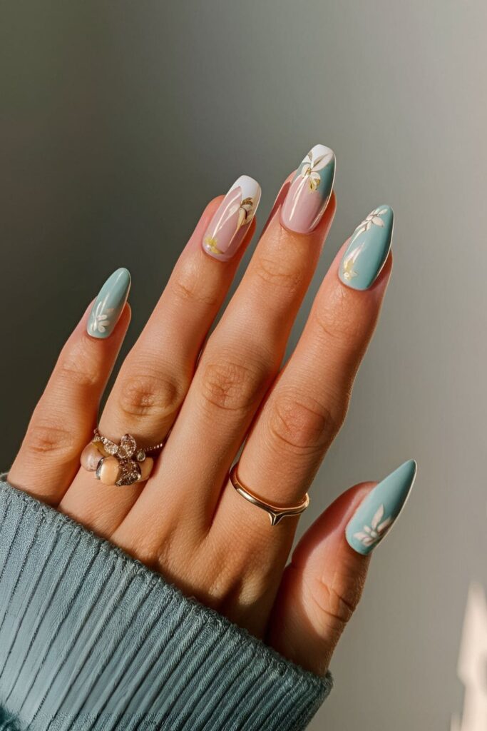 Light turquoise nails with delicate white and pink floral designs, evoking a fresh and airy fall feel