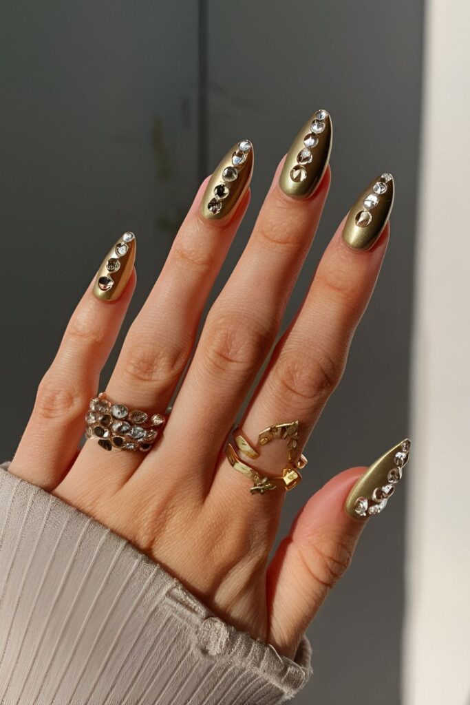 Luxurious gold acrylic nails adorned with strategically placed rhinestones for a glamorous appearance