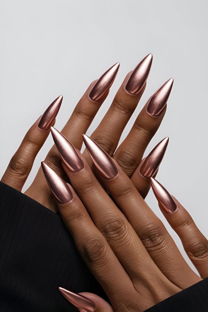 Luxurious rose gold pink metallic acrylic nails, enhancing dark skin tones with a glossy, high-fashion finish