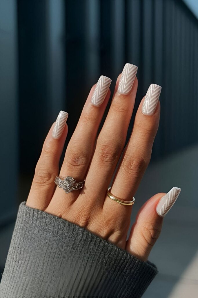 Manicure with a neutral base and small herringbone patterns in black or white, offering a sophisticated and chic minimalist look