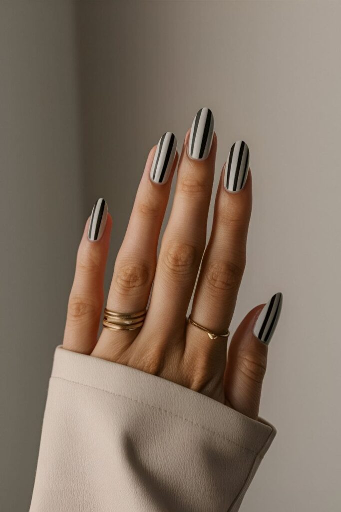 Minimalist nails with clean black and white horizontal, vertical, and diagonal stripes for a classic chic style