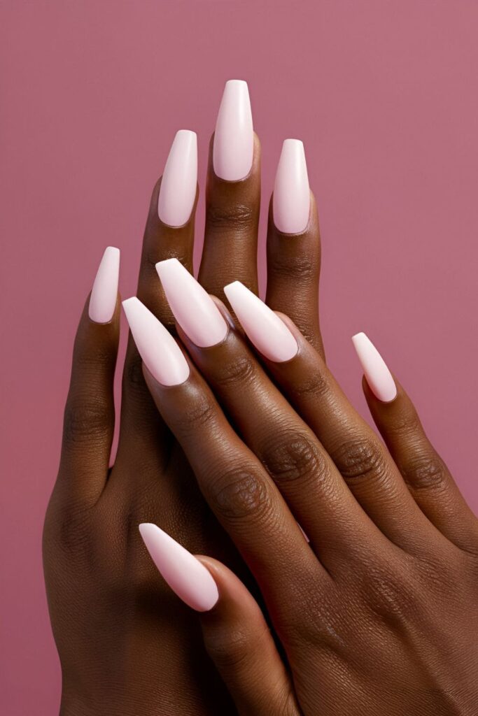 Modern pink matte acrylic nails, styled to complement dark skin tones with a sleek and sophisticated appearance