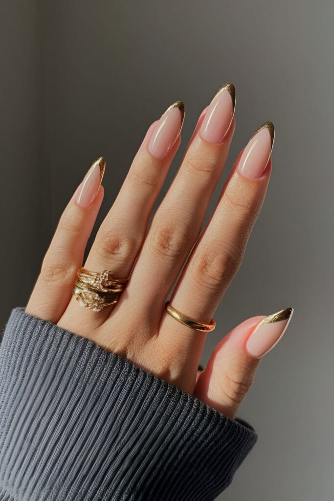 Modern twist on French tips with gold tips and a clear base, offering a sophisticated and glamorous style